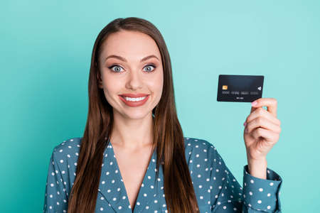 Portrait of positive cheerful girl hold credit card wear blue polka-dot blouse isolated over...