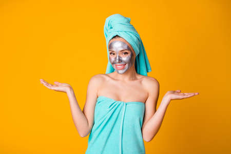 Photo of young attractive woman hold hands demonstrate advice recommend spa procedure isolated over yellow color backgroundの写真素材