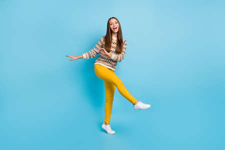 Photo of adorable shiny young woman dressed ornament pullover dancing isolated blue color backgroundの写真素材