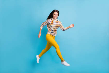 Full length photo of adorable young lady wear ornament sweater running jumping isolated blue color...
