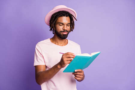 Photo of young afro handsome happy smiling positive man male guy hold write blue diary isolated on purple color backgroundの写真素材
