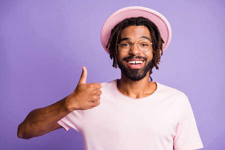 Photo portrait of man giving thumb up isolated on vivid purple colored backgroundの写真素材