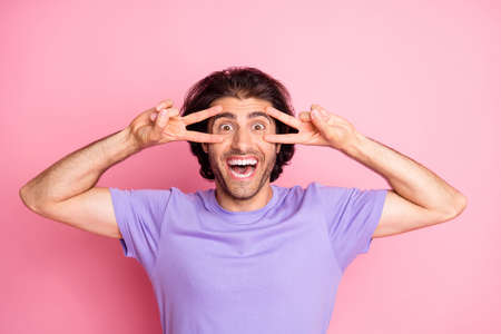 Photo of funky guy two hands show v-sign open mouth toothy smile wear purple t-shirt isolated pastel...