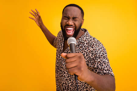 Close-up portrait of his he nice attractive handsome cheerful cheery guy singing karaoke pop soul jazz isolated over bright vivid shine vibrant yellow color backgroundの写真素材