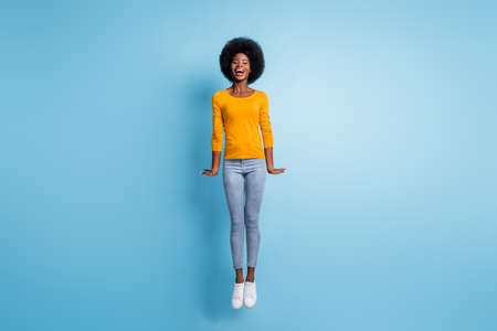 Photo portrait full body of woman jumping straight up isolated on pastel blue colored background