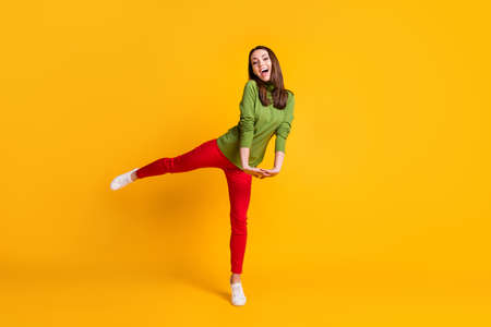 Full length body size view of attractive cheerful girl jumping having fun holiday isolated bright yellow color backgroundの写真素材