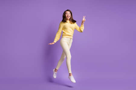 Photo portrait full body view of girl jumping up showing v-sign isolated on bright purple colored...