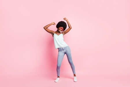 Full body photo of funny dancing lady closed eyes wear light blue tank-top isolated on pastel pink...