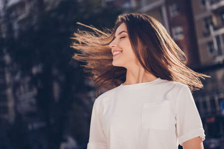 Photo portrait of woman waving hair smiling outdoorsの写真素材
