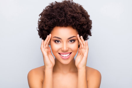 Close up photo of charming afro american girl touch her eyes enjoy skincare cosmetology correction make-up tone skin flawless pure fresh isolated over grey color backgroundの写真素材