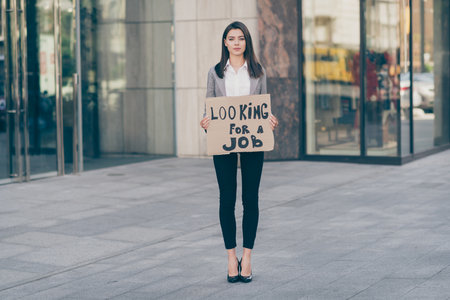 Full size photo of serious businesswoman hold card look for job wear blazer outdoors in donwtown...