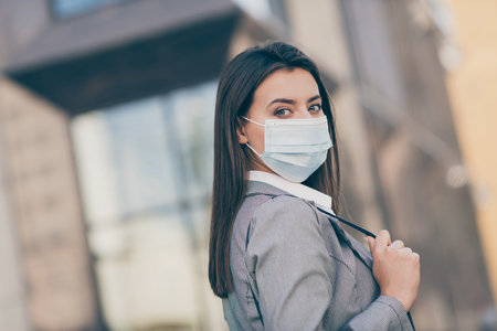 Profile side photo of serious attractive business person wear respiratory mask pandemic jacket outside in outdoorsの写真素材