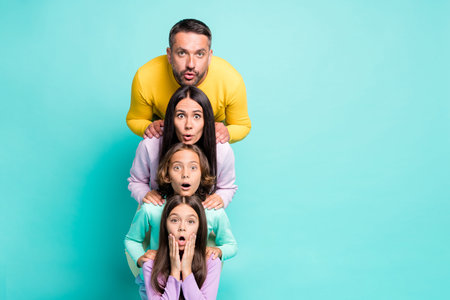 Photo portrait of big family shocked stacking heads on top of each other isolated on vivid turquoise...