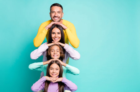Photo portrait of full family with small children stacking heads on top of each other next to...