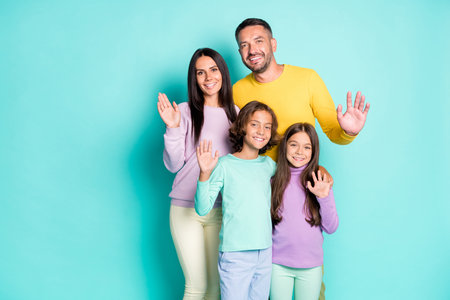 Photo portrait of full family with small kids waving hands saying hi isolated on vivid cyan colored...