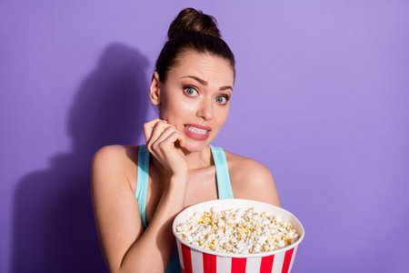 Close-up portrait of her she nice attractive lovely pretty worried terrified girl eating corn watching thriller genre film isolated on bright vivid shine vibrant lilac purple violet color backgroundの写真素材
