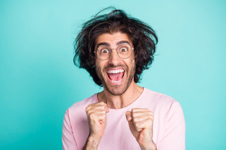 Close up portrait of funny hairdo person yell arms fist up achievement isolated on turquoise color backgroundの写真素材