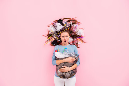 Top view above high angle flat lay flatlay lie concept of her she irritated annoyed evil girl holding junk single use global disaster solution life change isolated on pink pastel color backgroundの写真素材