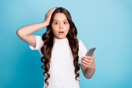 Close-up portrait of her she nice attractive amazed puzzled confused wavy-haired girl using device browsing reading fake news isolated bright vivid shine vibrant blue teal turquoise color backgroundの写真素材
