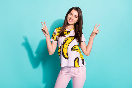 Photo of pretty lovely girl make v-sign enjoy rest relax weekend wear fruit print summer outfit isolated over teal color backgroundの写真素材