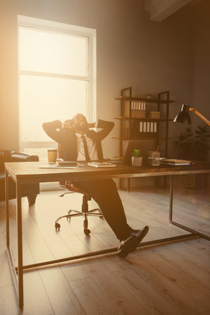 Vertical view of his he nice attractive classy cheerful cheery dreamy guy ceo boss chief employer specialist sitting in chair having rest pause at work place station indoors loft open spaceの写真素材