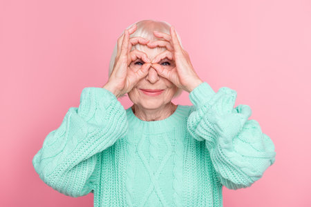 Photo portrait of playful senior lady blonde hair pretending wearing eyeglasses careless funny isolated on pastel pink color backgroundの写真素材