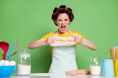 Photo furious outraged girl prepare tasty pizza dinner supper have cook problem hold dough scream wear style stylish trendy yellow dotted dress isolated green color backgroundの写真素材