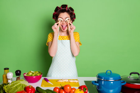 Portrait of her she nice attractive glamorous cheerful cheery funny wife preparing healthy meal dinner grimacing having fun closing eyes mushroom glasses isolated green color backgroundの写真素材