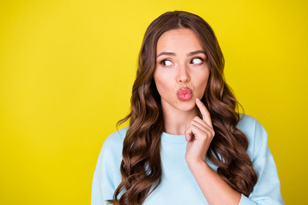 Photo of charming doubtful young girl look copyspace pouted lips finger face planning deciding...