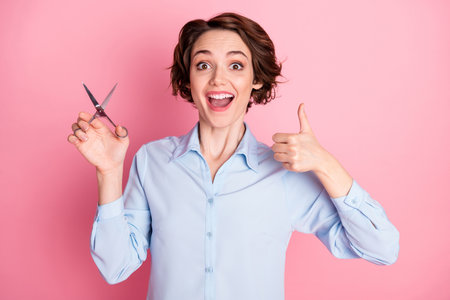 Photo of attractive excited lady hold professional scissors good mood raise thumb finger p advising...