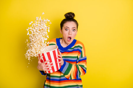 Photo of young woman watch horror movie terrified horrified scared isolated over yellow color backgroundの写真素材