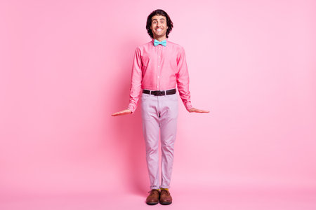 Full size photo of happy positive young gentleman beaming smile shy isolated on pastel pink color backgroundの写真素材