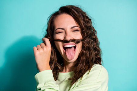 Close up portrait of delightful childish lady cover face curl wear green pullover isolated on...