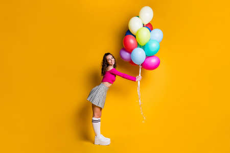 Full length body size photo of petty schoolgirl holding colorful balloons smiling prepearing for...