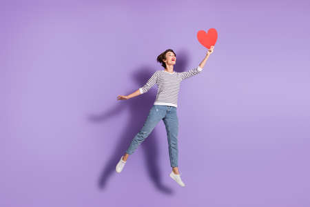 Full length photo of charming young woman wear casual outfit looking holding looking red paper heart...