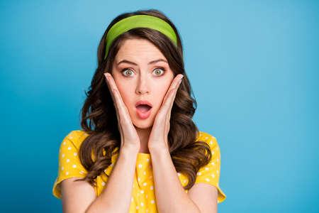 Photo portrait of shocked woman touching face with two hands isolated on pastel light blue colored...