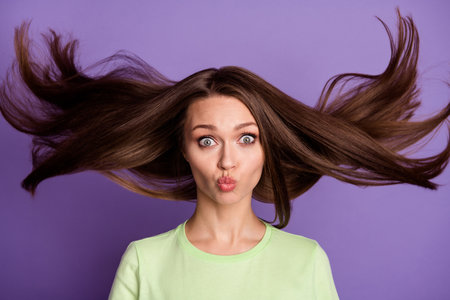 Close-up portrait of nice-looking attractive girlish funky comic cheery girl sending air kiss blowing clean smooth silky hair isolated bright vivid shine vibrant lilac violet color backgroundの写真素材