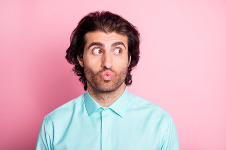 Photo of young handsome man lips pouted plump look empty space isolated over pink color backgroundの写真素材