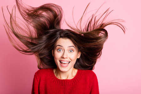 Photo of pretty young lady crazy open mouth air blow hairstyle wear red sweater isolated pink color backgroundの写真素材