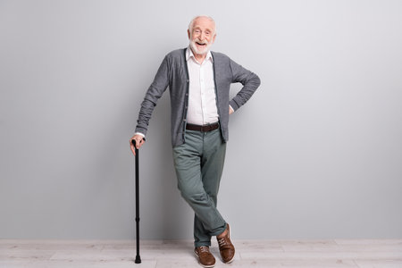 Full size photo of hooray old man stand laugh with wand wear dark sweater trousers isolated on grey wallの写真素材
