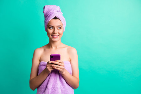 Photo of beautiful lady hold telephone hands look side empty space wear violet towels isolated teal...