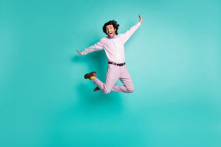 Full body photo of happy crazy gentleman jump dressed formal outfit yellow socks isolated on turquoise color backgroundの写真素材