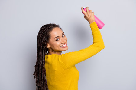 Photo of young afro girl happy positive smile enjoy draw graffiti aerosol spray isolated over grey...