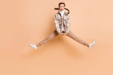 Full size photo of impressed nice girl jump wear white shirt trousers sneakers isolated on beige color backgroundの写真素材