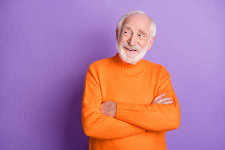 Portrait of handsome cheerful person crossed arms look empty space isolated on purple color backgroundの写真素材