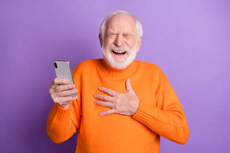 Photo of positive aged man closed eyes hand on chest laughing loud comedy blog post isolated on violet color backgroundの写真素材