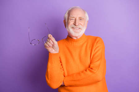 Portrait of positive man hand hold glasses toothy smile wear pullover isolated on purple color backgroundの写真素材