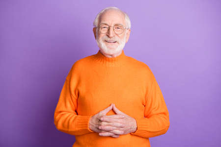 Photo of satisfied aged person eyewear smile arms fingers crossed on stomach isolated on violet color backgroundの写真素材