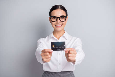 Photo of business lady demonstrate debit card toothy smile wear glasses white shirt isolated grey color backgroundの写真素材