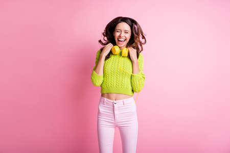 Photo of cheerful pretty young girl enjoy free time close eyes wear headphones green sweater...